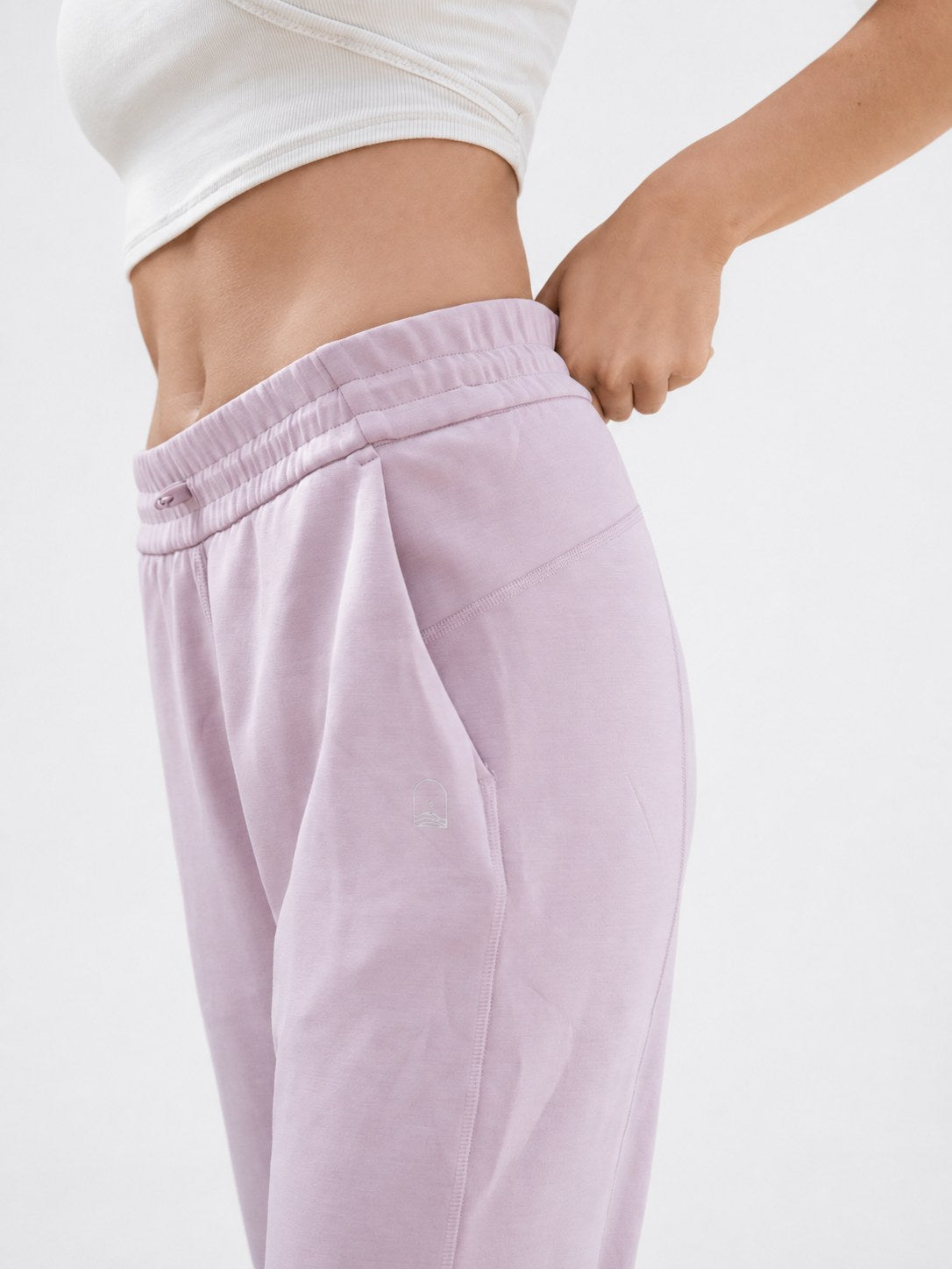 Pantalón Calm en rosa, detalle del bolsillo lateral y el logo Wuita